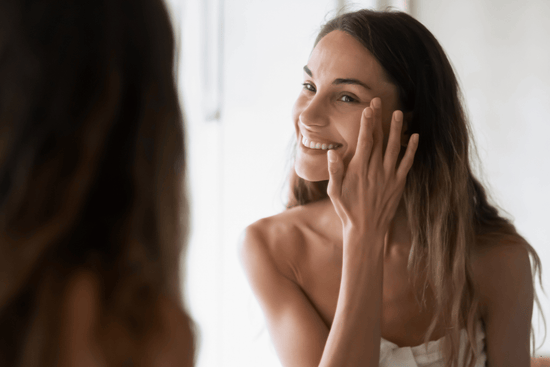 femme se regardant dans le miroir et touchant son visage